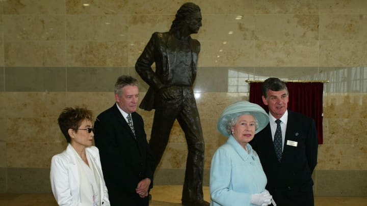 LIVERPOOL, UNITED KINGDOM – JULY 25: Queen Elizabeth II meets Yoko Ono in front of a statue designed by Tom Murphy (centre) of her husband, former Beatle John Lennon, during the opening of Liverpool’s John Lennon Airport on July 25, 2002 in Liverpool, England. (Photo by Anwar Hussein/Getty Images)