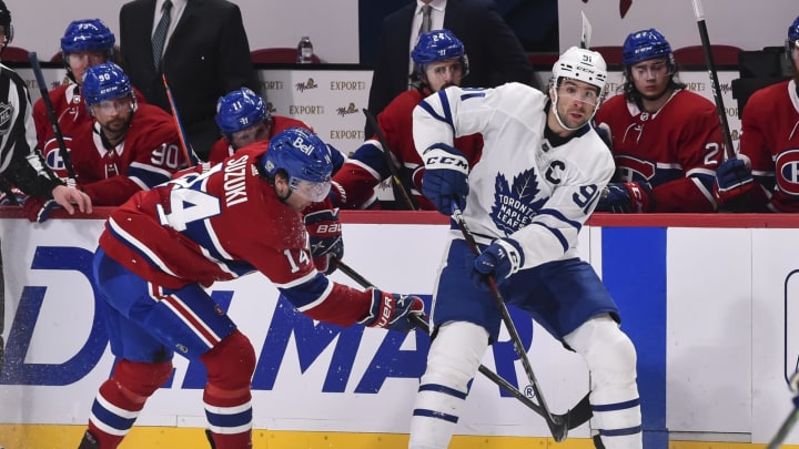 MONTREAL, QC – FEBRUARY 10: John Tavares #91 of the Toronto Maple Leafs plays the puck past Nick Suzuki #14 of the Montreal Canadiens during the third period at the Bell Centre on February 10, 2021 in Montreal, Canada. The Toronto Maple Leafs defeated the Montreal Canadiens 4-2.  (Photo by Minas Panagiotakis/Getty Images)