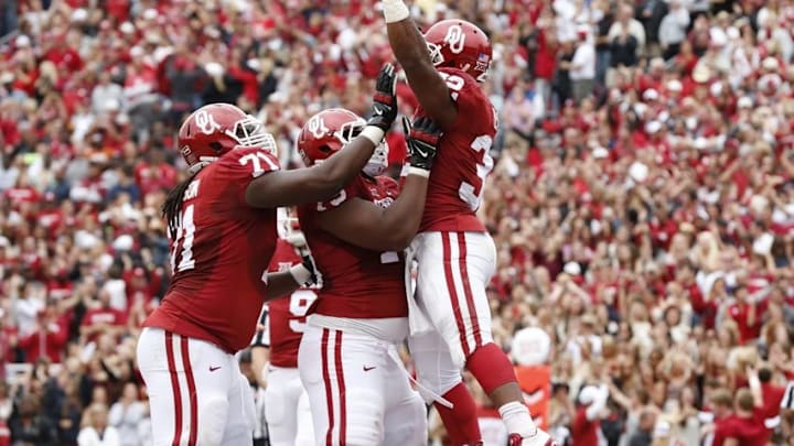Oct 11, 2014; Dallas, TX, USA; Oklahoma Sooners running back Semaje Perine (32) celebrates after scoring a touchdown in the fourth quarter with tackle Daryl Williams (79) and Tyrus Thompson (71) against the Texas Longhorns during the Red River showdown at the Cotton Bowl. Mandatory Credit: Matthew Emmons-USA TODAY Sports