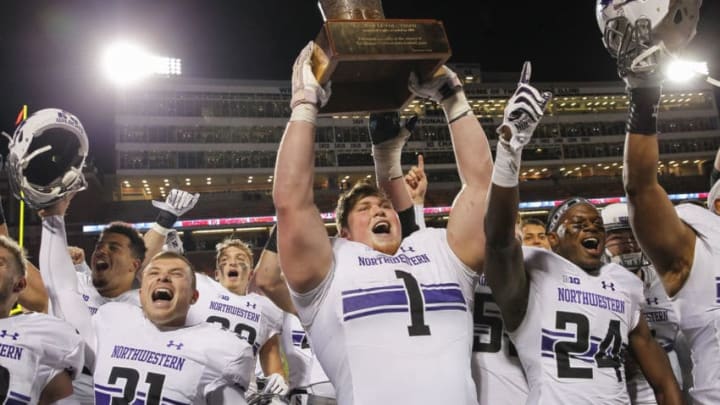 CHAMPAIGN, IL - NOVEMBER 25: Tyler Lancaster #1 of the Northwestern Wildcats hoists the Land of Lincoln Trophy after defeating the Illinois Fighting Illini 42-7 at Memorial Stadium on November 25, 2017 in Champaign, Illinois. (Photo by Michael Hickey/Getty Images)