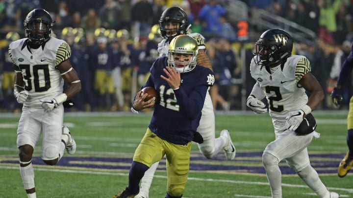 SOUTH BEND, IN – NOVEMBER 04: Ian Book #12 of the Notre Dame Fighting Irish runs for a first down chased by Cameron Glenn #2 and Ja’Cquez Williams #30 of the Wake Forest Demon Deacons at Notre Dame Stadium on November 4, 2017 in South Bend, Indiana. Notre Dame defeated Wake Forest 48-37. (Photo by Jonathan Daniel/Getty Images)