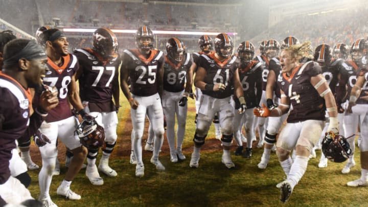 BLACKSBURG, VA - NOVEMBER 23: Linebacker Dax Hollifield #4 of the Virginia Tech Hokies is surrounded by teammates as he celebrates the victory against the Pittsburgh Panthers at Lane Stadium on November 23, 2019 in Blacksburg, Virginia. (Photo by Michael Shroyer/Getty Images)