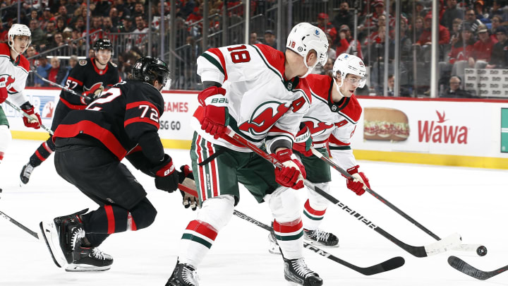 Jack Hughes (R) and Ondrej Palat (L) of the New Jersey Devils control the puck as Thomas Chabot (L) of the Ottawa Senators defends in Newark, New Jersey. | Photo by Sarah Stier for Getty Images.