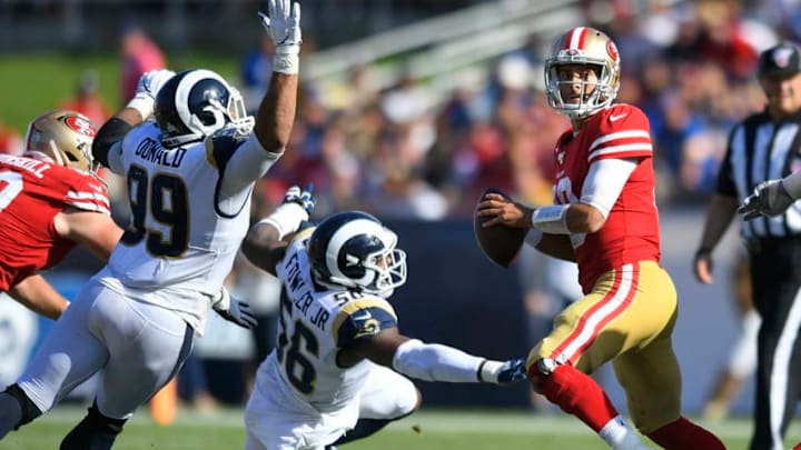 LOS ANGELES, CA - OCTOBER 13: Aaron Donald #99 of the Los Angeles Rams and Dante Fowler #56 put pressure on Jimmy Garoppolo #10 of the San Francisco 49ers who would fumble the ball in the fourth quarter at Los Angeles Memorial Coliseum on October 13, 2019 in Los Angeles, California. San Francisco won 20-7. (Photo by John McCoy/Getty Images)