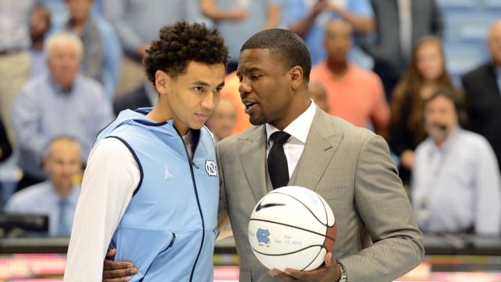 Dec 16, 2015; Chapel Hill, NC, USA; North Carolina Tar Heels guard Marcus Paige (5) receives an award from former player Shammond Williams (right) after setting the record for the most career three pointers prior to a game against the Tulane Green Wave at Dean E. Smith Center. Mandatory Credit: Rob Kinnan-USA TODAY Sports