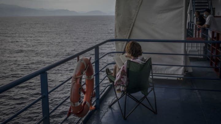 AT SEA, GREECE - AUGUST 8: A woman reads a book on the dock of a passenger ship sailing from Italy to Greece on August 8, 2020 at sea between Italy and Greece. Passenger ships resume sailings more than three months after they were suspended due to coronavirus travel restrictions. (Photo by Siegfried Modola/Getty Images)
