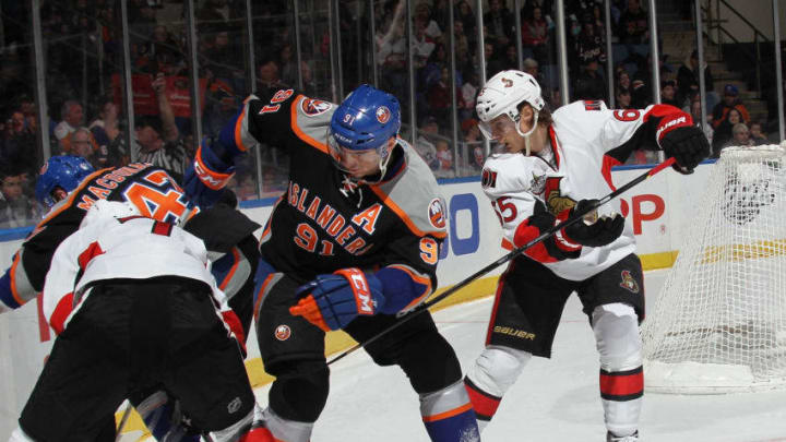 UNIONDALE, NY - FEBRUARY 20: Erik Karlsson #65 of the Ottawa Senators checks John Tavares #91 of the New York Islanders at the Nassau Veterans Memorial Coliseum on February 20, 2012 in Uniondale, New York. (Photo by Bruce Bennett/Getty Images)