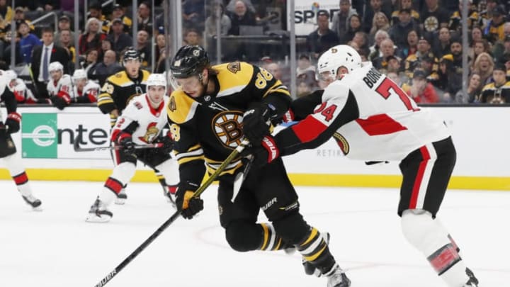 BOSTON, MA - NOVEMBER 02: Boston Bruins right wing David Pastrnak (88) keeps the puck from Ottawa Senators defenseman Mark Borowiecki (74) during a game between the Boston Bruins and the Ottawa Senators on November 2, 2019, at TD Garden in Boston, Massachusetts. (Photo by Fred Kfoury III/Icon Sportswire via Getty Images)