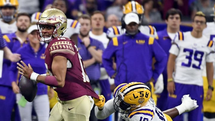 Sep 4, 2022; New Orleans, Louisiana, USA; Florida State Seminoles quarterback Jordan Travis (13) avoids a tackle by Louisiana State Tigers defensive end BJ Ojulari (18) during the second half at Caesars Superdome. Mandatory Credit: Melina Myers-USA TODAY Sports