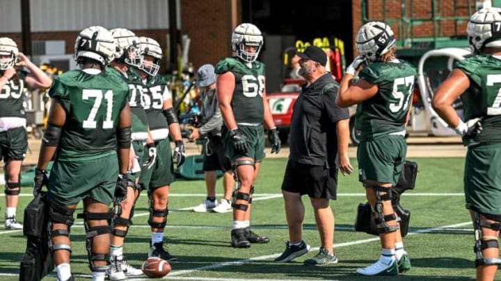 Michigan State's offensive line coach Chris Kapilovic, center, talks with players during the opening day of MSU's football fall camp on Thursday, Aug. 3, 2023, in East Lansing.