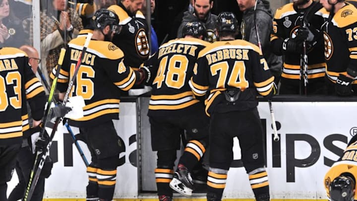 BOSTON, MA - MAY 29: Boston Bruins defenseman Matt Grzelcyk (48) is helped off the ice after getting drilled into the glass. During Game 2 of the Stanley Cup Finals featuring the Boston Bruins against the St. Louis Blues on May 29, 2019 at TD Garden in Boston, MA. (Photo by Michael Tureski/Icon Sportswire via Getty Images)