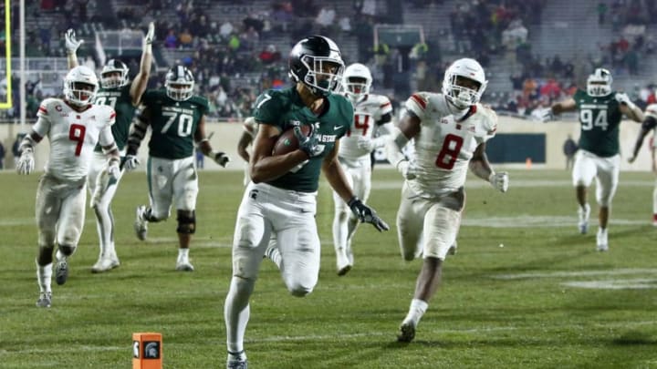 EAST LANSING, MI - NOVEMBER 24: Wide receiver Cody White #7 of the Michigan State Spartans is pursued by defensive back Saquan Hampton #9 of the Rutgers Scarlet Knights and linebacker Tyshon Fogg #8 of the Rutgers Scarlet Knights on a 22-yard touchdown run during the fourth quarter at Spartan Stadium on November 24, 2018 in East Lansing, Michigan. Michigan State defeated Rutgers 14-10. (Photo by Duane Burleson/Getty Images)