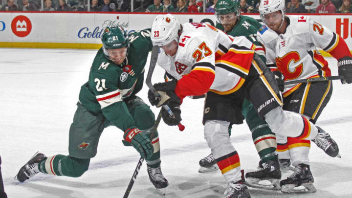 ST. PAUL, MN - DECEMBER 15: Eric Fehr #21 of the Minnesota Wild and Sean Monahan #23 of the Calgary Flames battle for the puck after a face-off during a game at Xcel Energy Center on December 15, 2018 in St. Paul, Minnesota.(Photo by Bruce Kluckhohn/NHLI via Getty Images)
