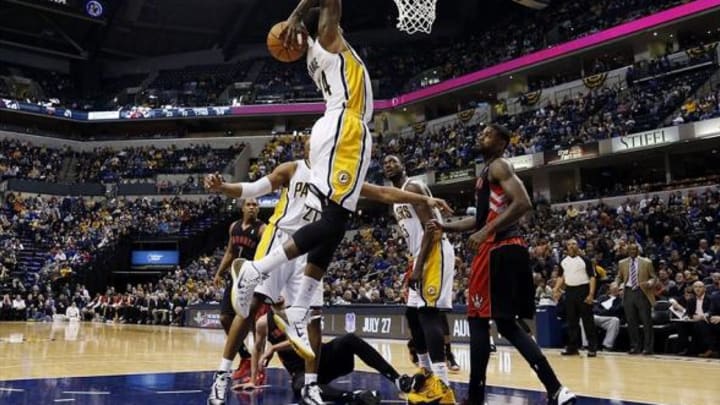 Jan 7, 2014; Indianapolis, IN, USA; Indiana Pacers forward Paul George (24) dunks against Toronto Raptors forward Amir Johnson (15) at Bankers Life Fieldhouse. Indiana defeats Toronto 86-79. Mandatory Credit: Brian Spurlock-USA TODAY Sports