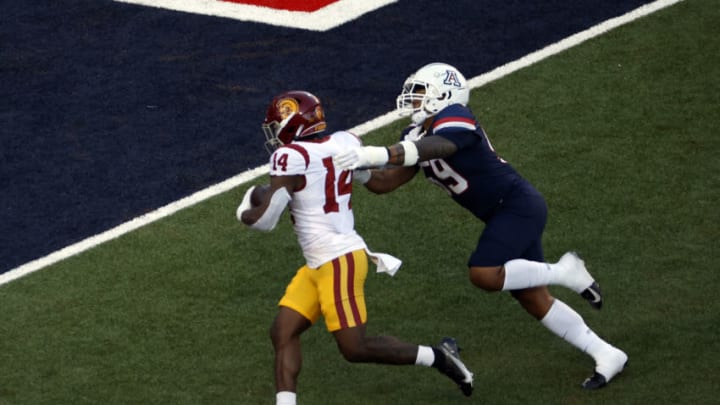 TUCSON, ARIZONA - OCTOBER 29: Running back Raleek Brown #14 of the USC Trojans stiff arms linebacker Jacob Manu #59 of the Arizona Wildcats during the first half at Arizona Stadium on October 29, 2022 in Tucson, Arizona. (Photo by Chris Coduto/Getty Images)