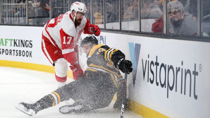 BOSTON, MASSACHUSETTS - NOVEMBER 04: Filip Hronek #17 of the Detroit Red Wings checks Charlie Coyle #13 of the Boston Bruins into the boards during the first period at TD Garden on November 04, 2021 in Boston, Massachusetts. (Photo by Maddie Meyer/Getty Images)