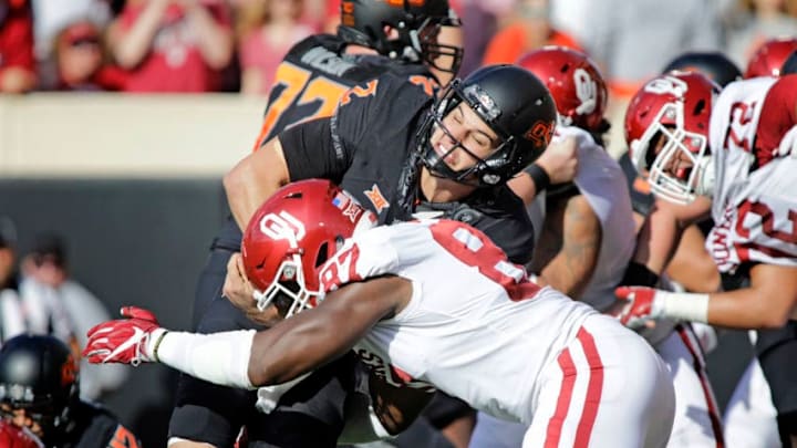 STILLWATER, OK - NOVEMBER 04: Quarterback Mason Rudolph #2 of the Oklahoma State Cowboys is hit by defensive end D.J. Ward #87 of the Oklahoma Sooners at Boone Pickens Stadium on November 4, 2017 in Stillwater, Oklahoma. Oklahoma defeated Oklahoma State 62-52. (Photo by Brett Deering/Getty Images)