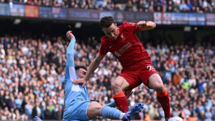 Manchester City’s French defender Aymeric Laporte (L) tackles Liverpool’s Portuguese striker Diogo Jota during the English Premier League football match between Manchester City and Liverpool at the Etihad Stadium in Manchester, north west England, on April 10, 2022. (Photo by Paul ELLIS / AFP)