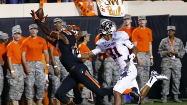 Sep 25, 2014; Stillwater, OK, USA; Oklahoma State Cowboys wide receiver Jhajuan Seales (81) makes a catch in front of Texas Tech Red Raiders defensive back Justis Nelson (31) during the third quarter of a game at Boone Pickens Stadium. Oklahoma State won 45-35. Mandatory Credit: Alonzo Adams-USA TODAY Sports