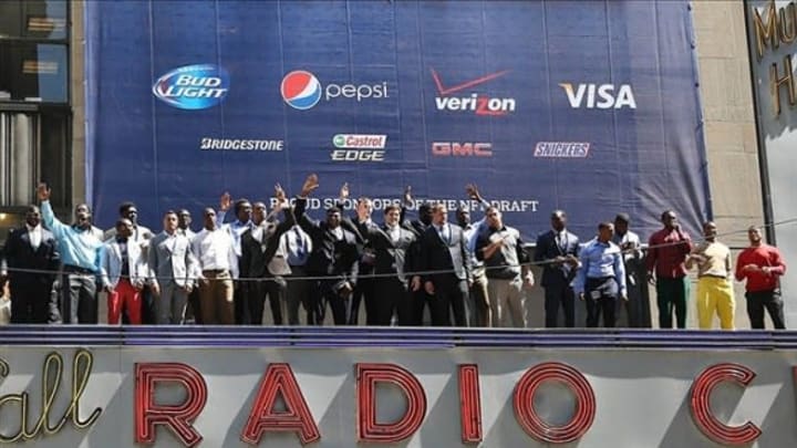 Apr 24, 2013; New York, NY, USA; Select NFL prospects wave atop the marquee before for the 2013 NFL Draft at Radio City Music Hall. Mandatory Credit: Debby Wong-USA TODAY Sports