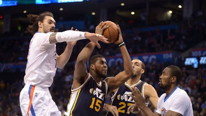 Mar 24, 2016; Oklahoma City, OK, USA; Utah Jazz forward Derrick Favors (15) drives to the basket between Oklahoma City Thunder forward Serge Ibaka (9) and center Steven Adams (12) during the third quarter at Chesapeake Energy Arena. Mandatory Credit: Mark D. Smith-USA TODAY Sports