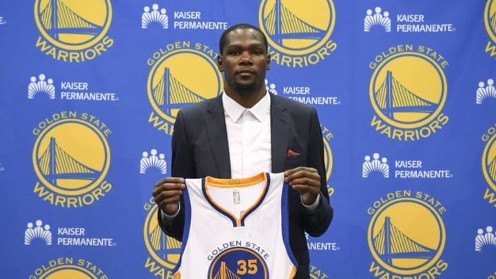 Jul 7, 2016; Oakland, CA, USA; Kevin Durant poses for a photo with his jersey during a press conference after signing with the Golden State Warriors at the Warriors Practice Facility. Mandatory Credit: Kyle Terada-USA TODAY Sports