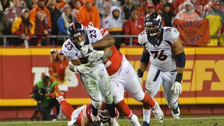 Dec 25, 2016; Kansas City, MO, USA; Denver Broncos running back Devontae Booker (23) runs the ball tackled by Kansas City Chiefs nose tackle Dontari Poe (92) during the first half at Arrowhead Stadium. Mandatory Credit: Denny Medley-USA TODAY Sports