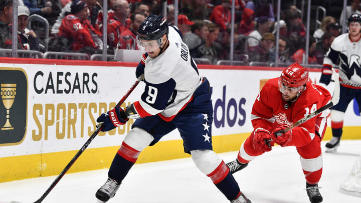 Feb 21, 2023; Washington, District of Columbia, USA; Washington Capitals defenseman Dmitry Orlov (9) clears the puck as Detroit Red Wings center Robby Fabbri (14) looks on during the second period at Capital One Arena. Mandatory Credit: Brad Mills-USA TODAY Sports