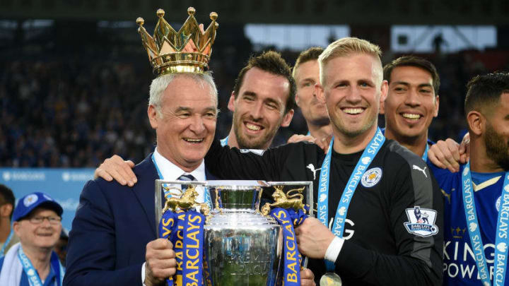 LEICESTER, ENGLAND - MAY 07: Claudio Ranieri poses with the Premier League Trophy while Kasper Schmeichel puts the crown on the head of the manager as players and staffs celebrate the season champions after the Barclays Premier League match between Leicester City and Everton at The King Power Stadium on May 7, 2016 in Leicester, United Kingdom. (Photo by Michael Regan/Getty Images)