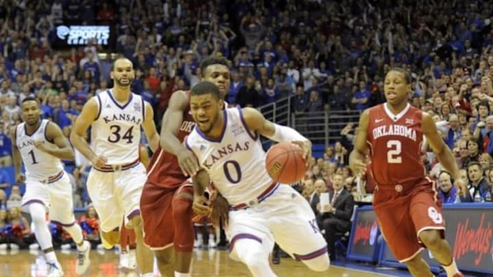 Jan 4, 2016; Lawrence, KS, USA; Kansas Jayhawks guard Frank Mason III (0) is fouled by Oklahoma Sooners guard Buddy Hield (24) in the third overtime at Allen Fieldhouse. Kansas won the game 109-106 in triple overtime. Mandatory Credit: John Rieger-USA TODAY Sports