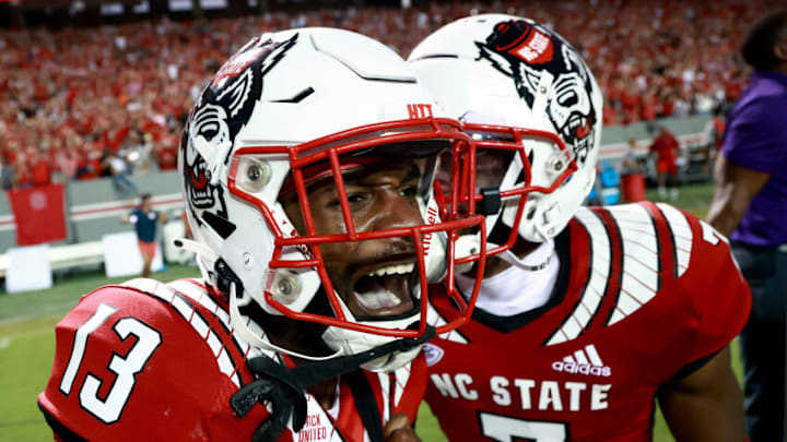 RALEIGH, NORTH CAROLINA - SEPTEMBER 25: Tyler Baker-Williams #13 of the North Carolina State Wolfpack celebrates after his game-winning pass breakup against the Clemson Tigers during the second overtime of their game at Carter-Finley Stadium on September 25, 2021 in Raleigh, North Carolina. North Carolina State won 27-21 in double overtime. (Photo by Grant Halverson/Getty Images)