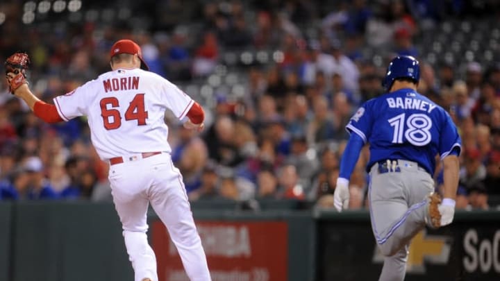 September 15, 2016; Anaheim, CA, USA; Los Angeles Angels relief pitcher Mike Morin (64) tags out Toronto Blue Jays third baseman Darwin Barney (18) in the seventh inning at Angel Stadium of Anaheim. Mandatory Credit: Gary A. Vasquez-USA TODAY Sports