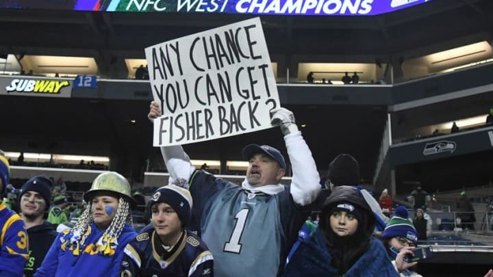 Dec 15, 2016; Seattle, WA, USA; Seattle Seahawks fan holds sign that reads "Any chance you can get (coach jeff Fisher) back?" during a NFL football game against the Los Angeles Rams at CenturyLink Field. The Seahawks defeated the Rams 24-3. Mandatory Credit: Kirby Lee-USA TODAY Sports