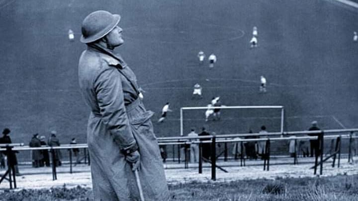 Un soldat surveille d'éventuels raids aériens lors d'un match Charlton-Arsenal, en 1940. Un soldat surveille d'éventuels raids aériens lors d'un match Charlton-Arsenal, en 1940.