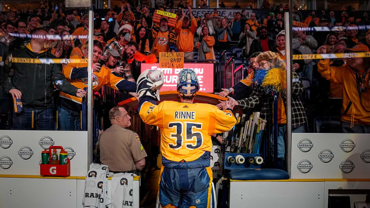 Former Nashville Predators goalie Pekka Rinne puts on a jersey