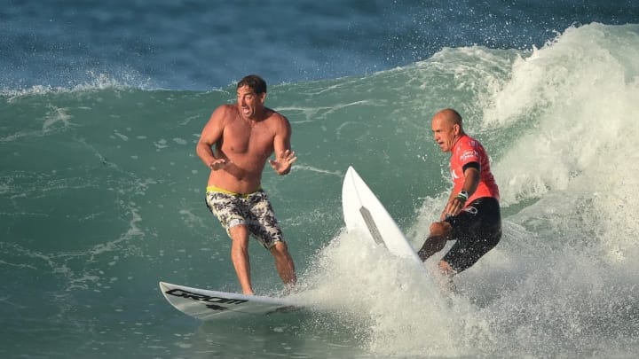 Surf coach Ricky Schaffer almost gets tied up with Kelly Slater prior to Kelly's first heat.