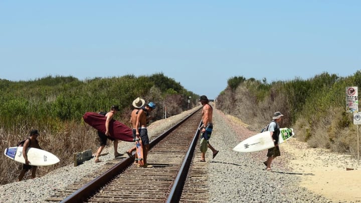 Trestles is named for the bridges that lift the railroad tracks over the stream that empties into the Pacific Ocean. Surfers walk down the trails past