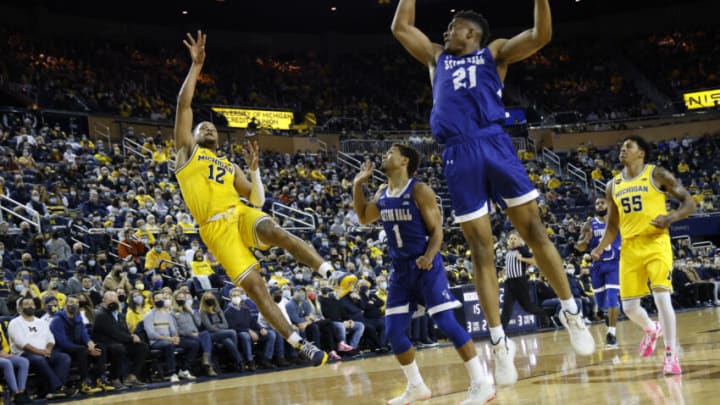 Nov 16, 2021; Ann Arbor, Michigan, USA; Michigan Wolverines guard DeVante' Jones (12) shoots over Seton Hall Pirates guard Bryce Aiken (1) and center Ike Obiagu (21) in the first half at Crisler Center. Mandatory Credit: Rick Osentoski-USA TODAY Sports