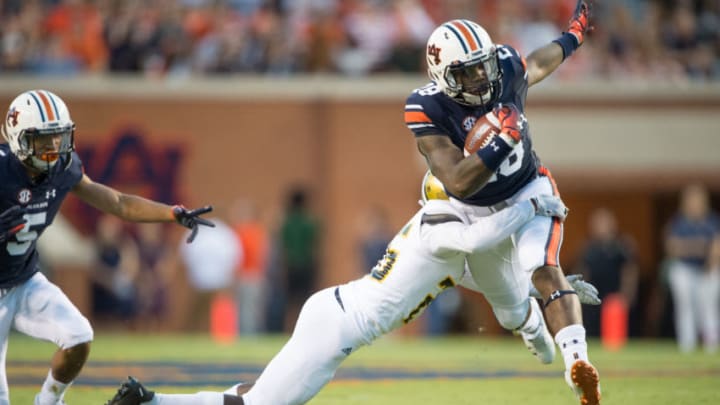 AUBURN, AL - SEPTEMBER 8: Running back JaTarvious Whitlow #28 of the Auburn Tigers looks to escape a tackle by defensive back Lawrence Tolbert #25 of the Alabama State Hornets during the first quarter at Jordan-Hare Stadium on September 8, 2018 in Auburn, Alabama. (Photo by Michael Chang/Getty Images)