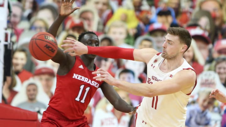 Dec 22, 2020; Madison, Wisconsin, USA; Wisconsin Badgers forward Micah Potter (11) passes the ball past Nebraska Cornhuskers forward Lat Mayen (11) during the second half at the Kohl Center. Mandatory Credit: Mary Langenfeld-USA TODAY Sports