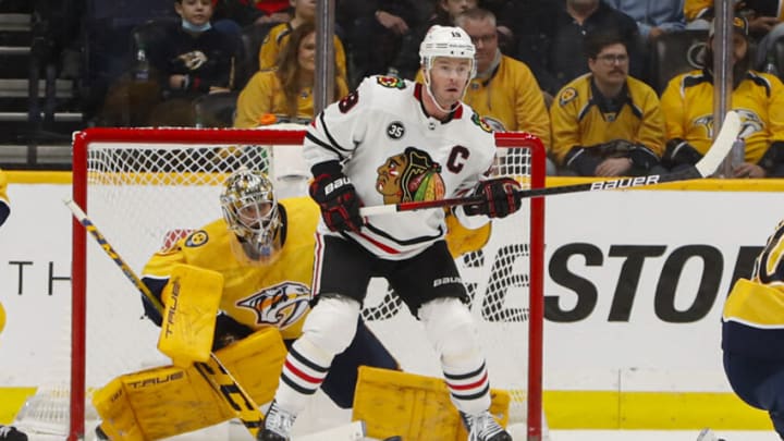 NASHVILLE, TENNESSEE - JANUARY 01: Jonathan Toews #19 of the Chicago Blackhawks stands in front of goalie Juuse Saros #74 of the Nashville Predators during the first period at Bridgestone Arena on January 01, 2022 in Nashville, Tennessee. (Photo by Frederick Breedon/Getty Images)