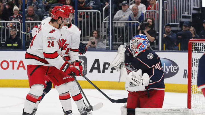 Jan 12, 2023; Columbus, Ohio, USA; Carolina Hurricanes center Seth Jarvis (24) looks for a rebound as Columbus Blue Jackets goalie Joonas Korpisalo (70) makes the save during the first period at Nationwide Arena. Mandatory Credit: Russell LaBounty-USA TODAY Sports