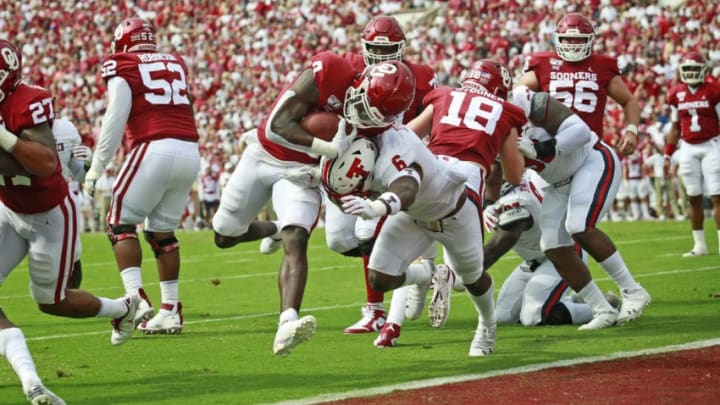 NORMAN, OK - SEPTEMBER 28: Running back Trey Sermon #4 of the Oklahoma Sooners hits linebacker Riko Jeffers #6 of the Texas Tech Red Raiders on his way to a touchdown at Gaylord Family Oklahoma Memorial Stadium on September 28, 2019 in Norman, Oklahoma. (Photo by Brett Deering/Getty Images)