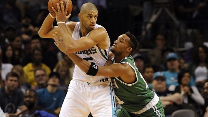Dec 23, 2015; Charlotte, NC, USA; Charlotte Hornets guard Nicolas Batum (5) passes the ball as he is defended by Boston Celtics guard forward Evan Turner (11) during the second half of the game at Time Warner Cable Arena. Celtics win 102-89. Mandatory Credit: Sam Sharpe-USA TODAY Sports