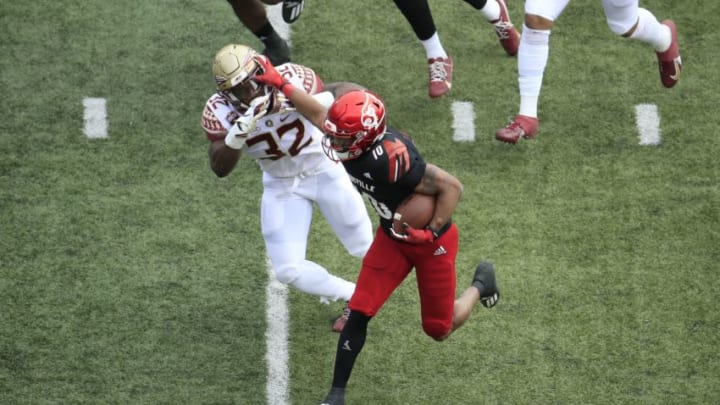 LOUISVILLE, KENTUCKY - OCTOBER 24: Javian Hawkins #10 of the Louisville Cardinals runs with the ball while defended by Stephen Dix Jr #32 of the Florida State Seminoles at Cardinal Stadium on October 24, 2020 in Louisville, Kentucky. (Photo by Andy Lyons/Getty Images)