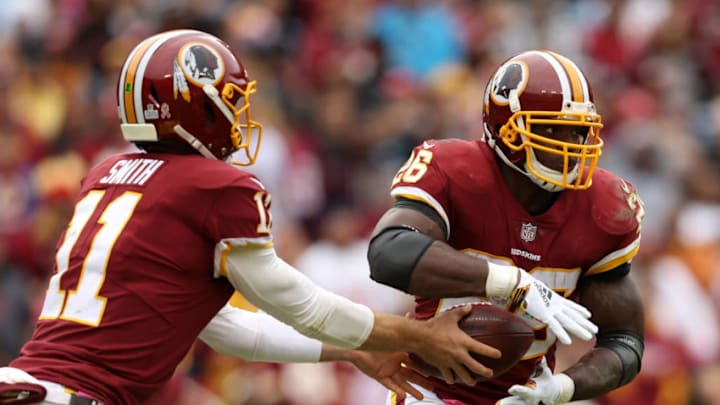 LANDOVER, MD - OCTOBER 14: Quarterback Alex Smith #11 of the Washington Redskins hands the ball off to running back Adrian Peterson #26 in the third quarter against the Carolina Panthers at FedExField on October 14, 2018 in Landover, Maryland. (Photo by Patrick Smith/Getty Images)