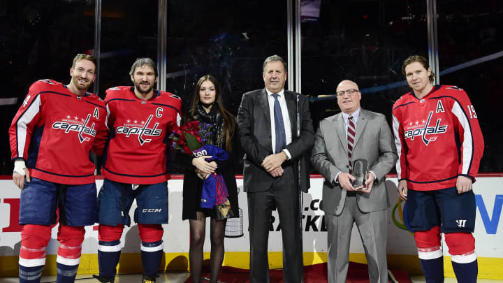 WASHINGTON, DC – APRIL 05: Alex Ovechkin #8 of the Washington Capitals stands with Brooks Orpik #44, his wife Nastya Ovechkina, Capitals president Dick Patrick, NHL Deputy Commissioner Bill Daly, and Nicklas Backstrom #19 during a pre-game ceremony honoring Ovechkin for playing in his 1,000th NHL game on April 1 against the Pittsburgh Penguins before a game against the Nashville Predators at Capital One Arena on April 5, 2018 in Washington, DC. (Photo by Patrick McDermott/NHLI via Getty Images)