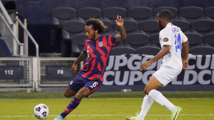 Jul 15, 2021; Kansas City, Kansas, USA; United States midfielder Gianluca Busio (6) kicks an assist as Martinique defender Dondon Gerald (4) looks on during CONCACAF Gold Cup Soccer group stage play at Children's Mercy Park. Mandatory Credit: Denny Medley-USA TODAY Sports