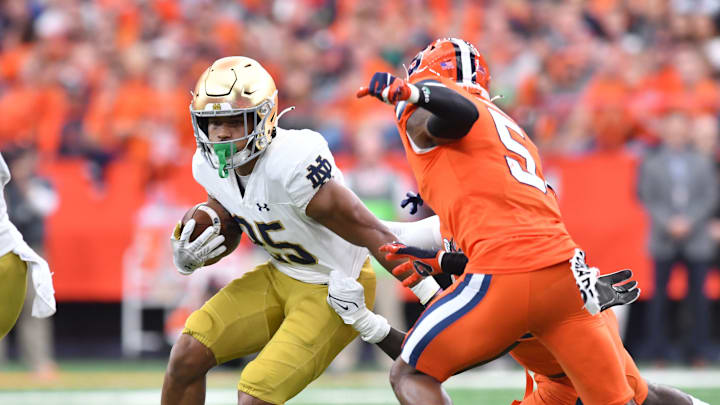 Oct 29, 2022; Syracuse, New York, USA; Notre Dame Fighting Irish running back Chris Tyree (25) moves through a hole as Syracuse Orange defensive back Alijah Clark (5) looks to tackle in the first quarter at JMA Wireless Dome. Mandatory Credit: Mark Konezny-USA TODAY Sports