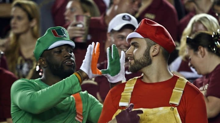 Oct 10, 2015; Tallahassee, FL, USA; A Miami Hurricanes fan and a Florida State Seminoles fan talk trash in the second quarter of their game at Doak Campbell Stadium. Mandatory Credit: Phil Sears-USA TODAY Sports